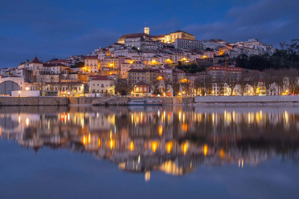 Une ville au bord de l’eau, illuminée la nuit avec son reflet scintillant.