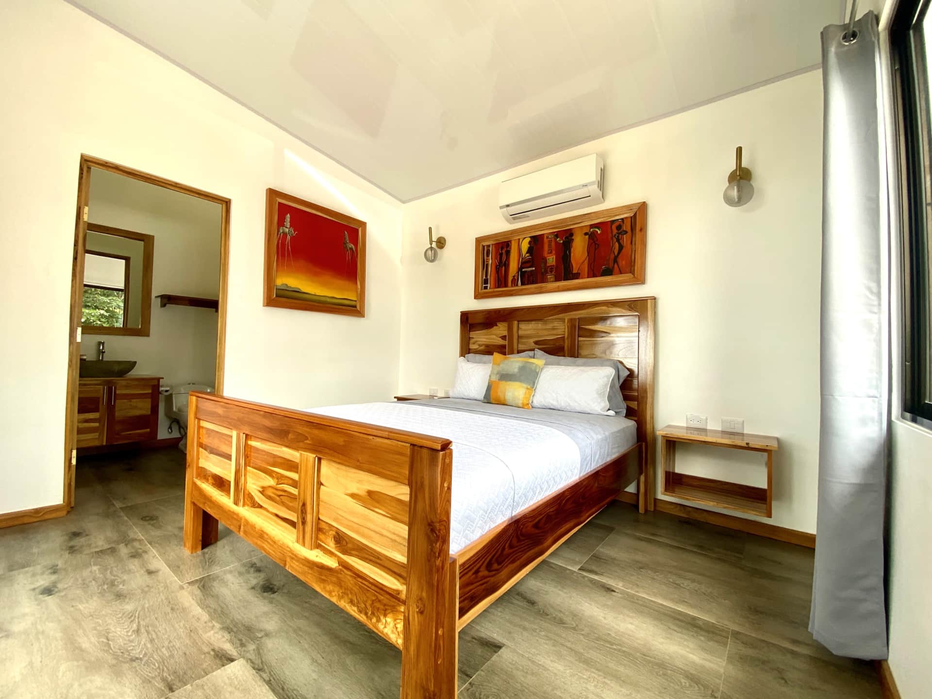 Chambre moderne avec lit en bois massif et salle de bain privée dans une villa à louer au Costa Rica