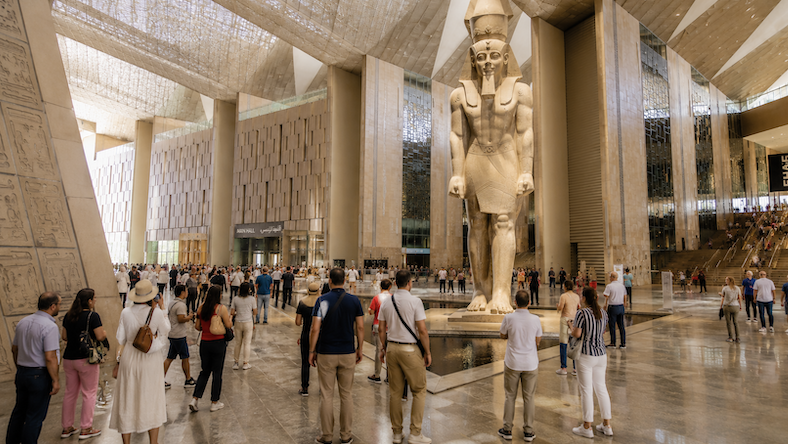 Visiteurs au Grand Musée Égyptien du Caire devant la statue de Ramsès II