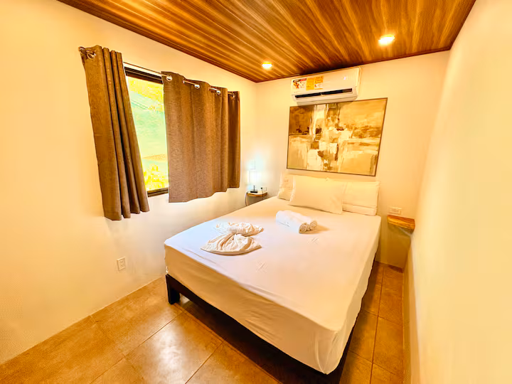 Chambre #3 de la villa de 6 chambres avec lit queen, climatisation et accès à une salle de bain partagée à Uvita au Costa Rica.