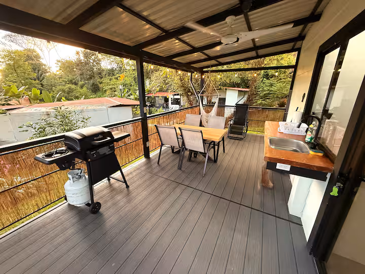 Terrasse couverte de la villa privée avec espace repas, barbecue et coin détente.