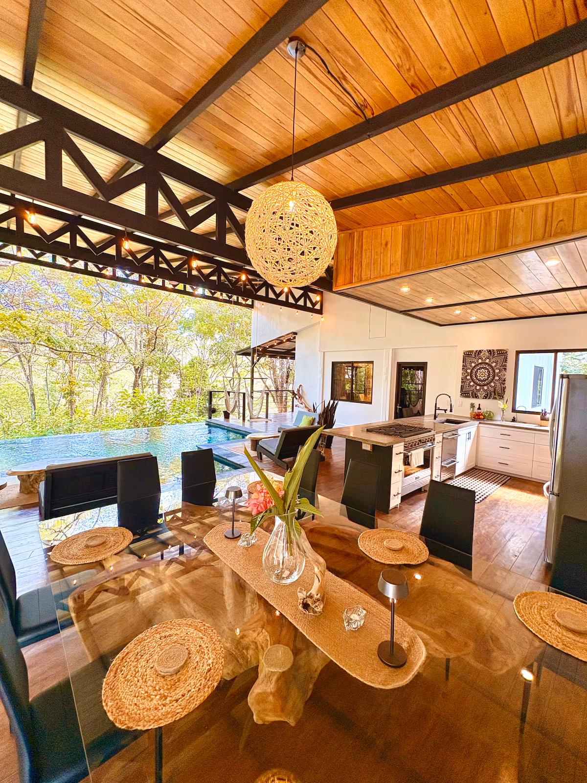 Salle à manger panoramique de la Villa 6 avec cuisine ouverte, piscine à débordement et vue sur la jungle