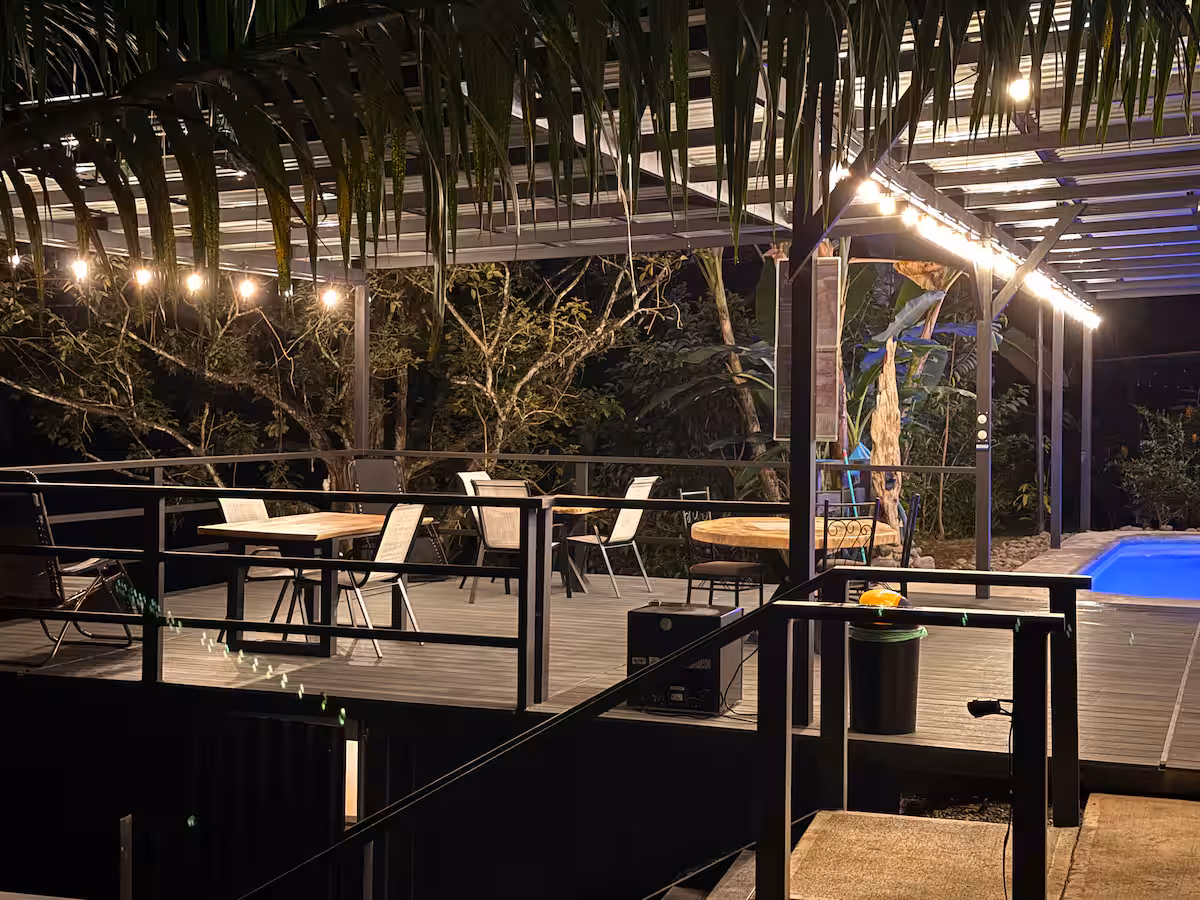Terrasse couverte avec tables et espace détente à proximité de la pis