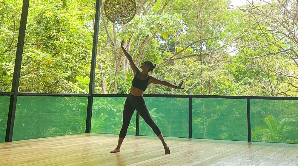 Pratique de yoga sur une plateforme ouverte entourée par la jungle tropicale du Costa Rica.