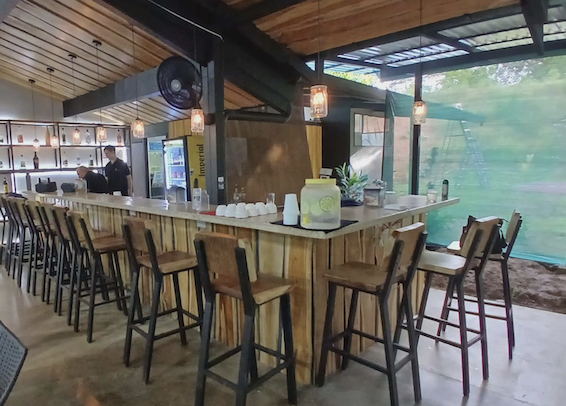 Restaurant-bar de l’Invictus Pickleball Club avec comptoir, espace repas et vue sur les terrains de jeu