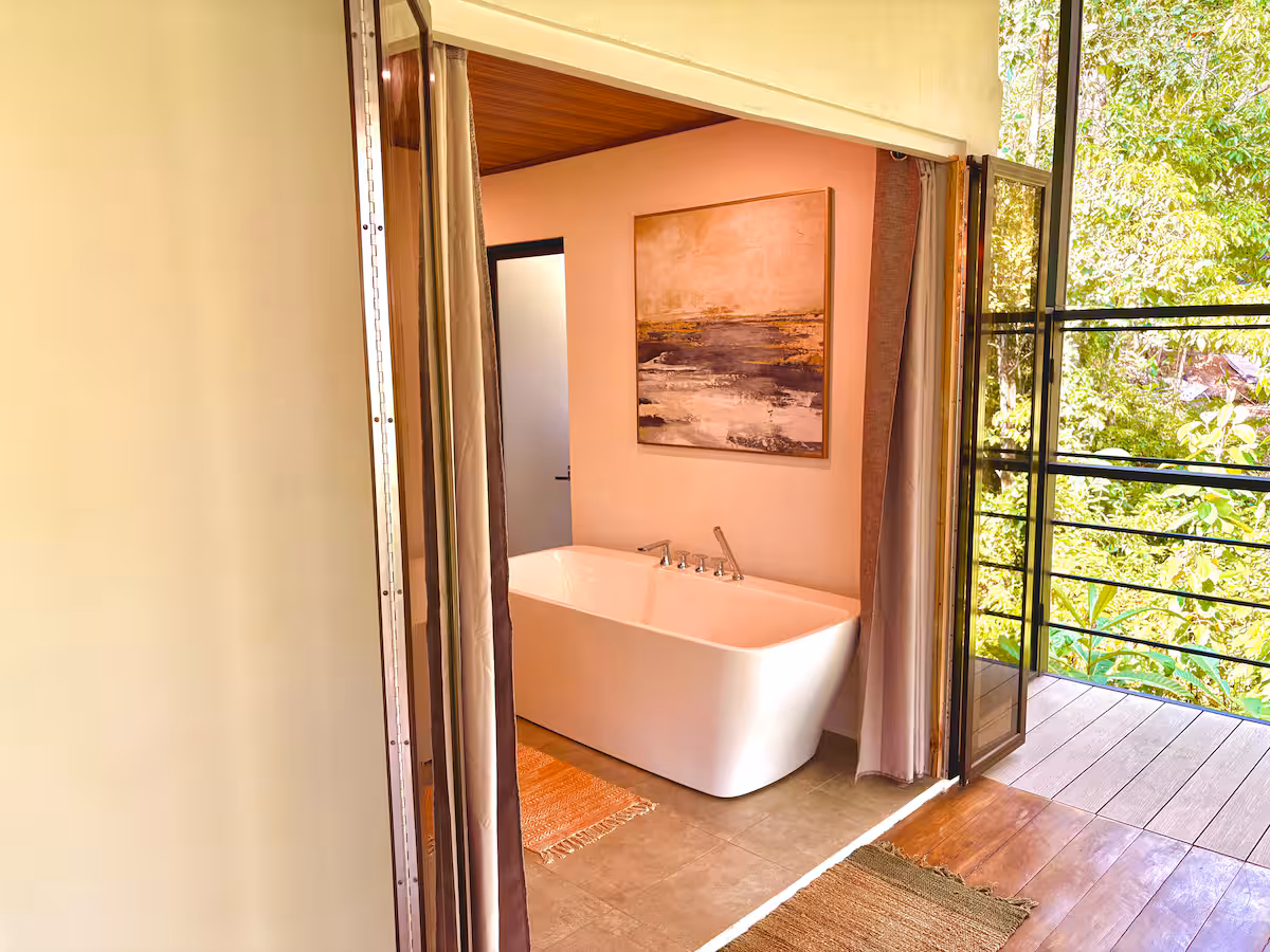 Salle de bain moderne de la Villa 6 avec baignoire et vue sur la forêt tropicale