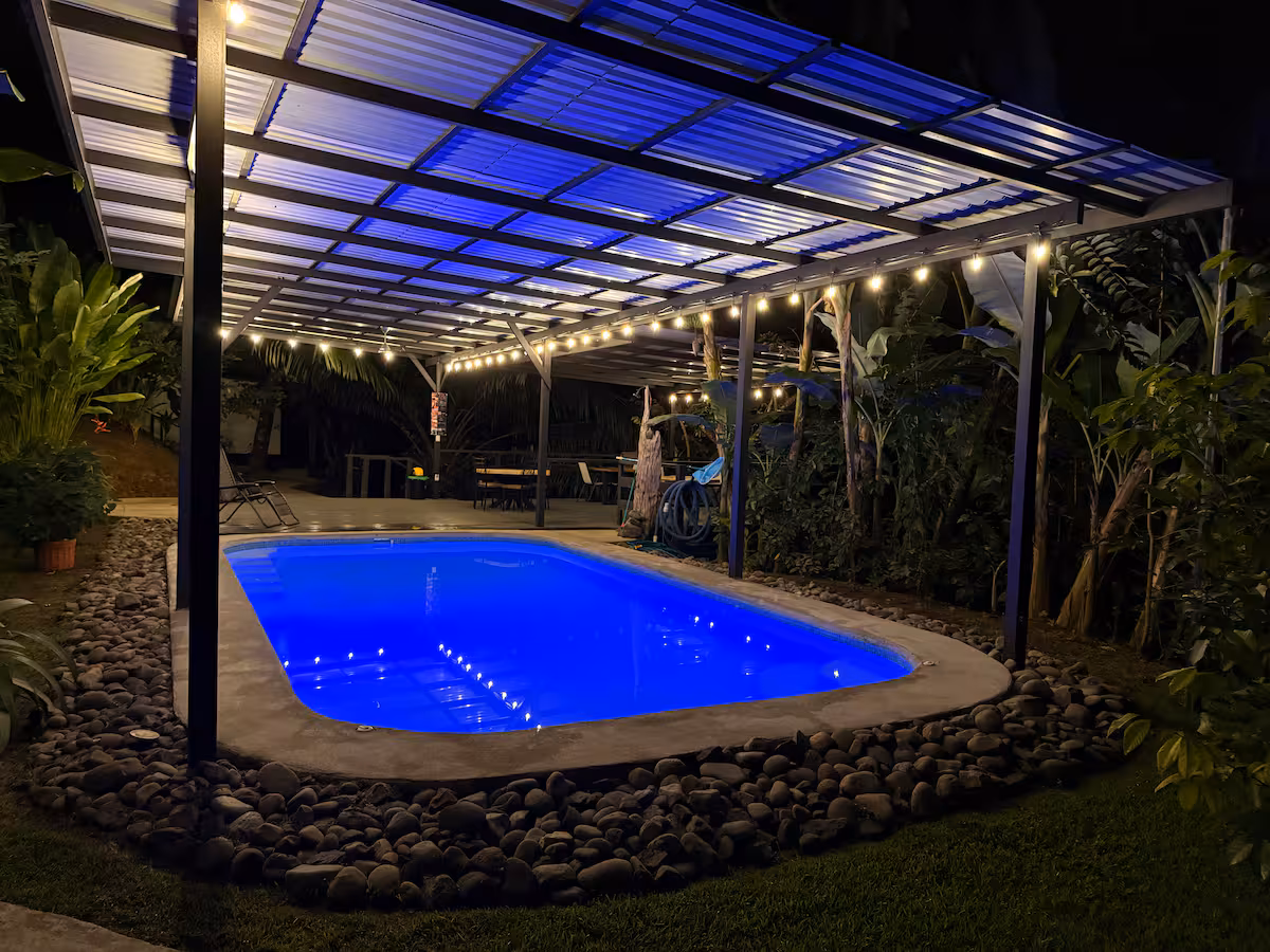 Piscine extérieure éclairée de nuit dans un cadre tropical à Uvita
