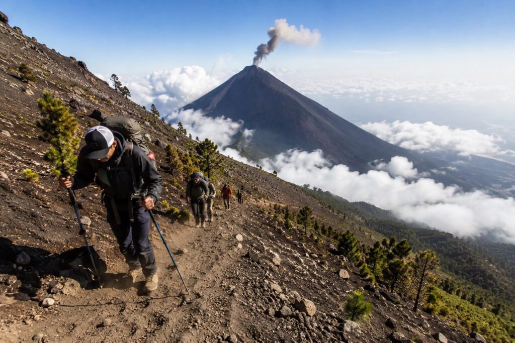 Randonneurs en pleine ascension du volcan Acatenango avec vue sur le volcan Fuego