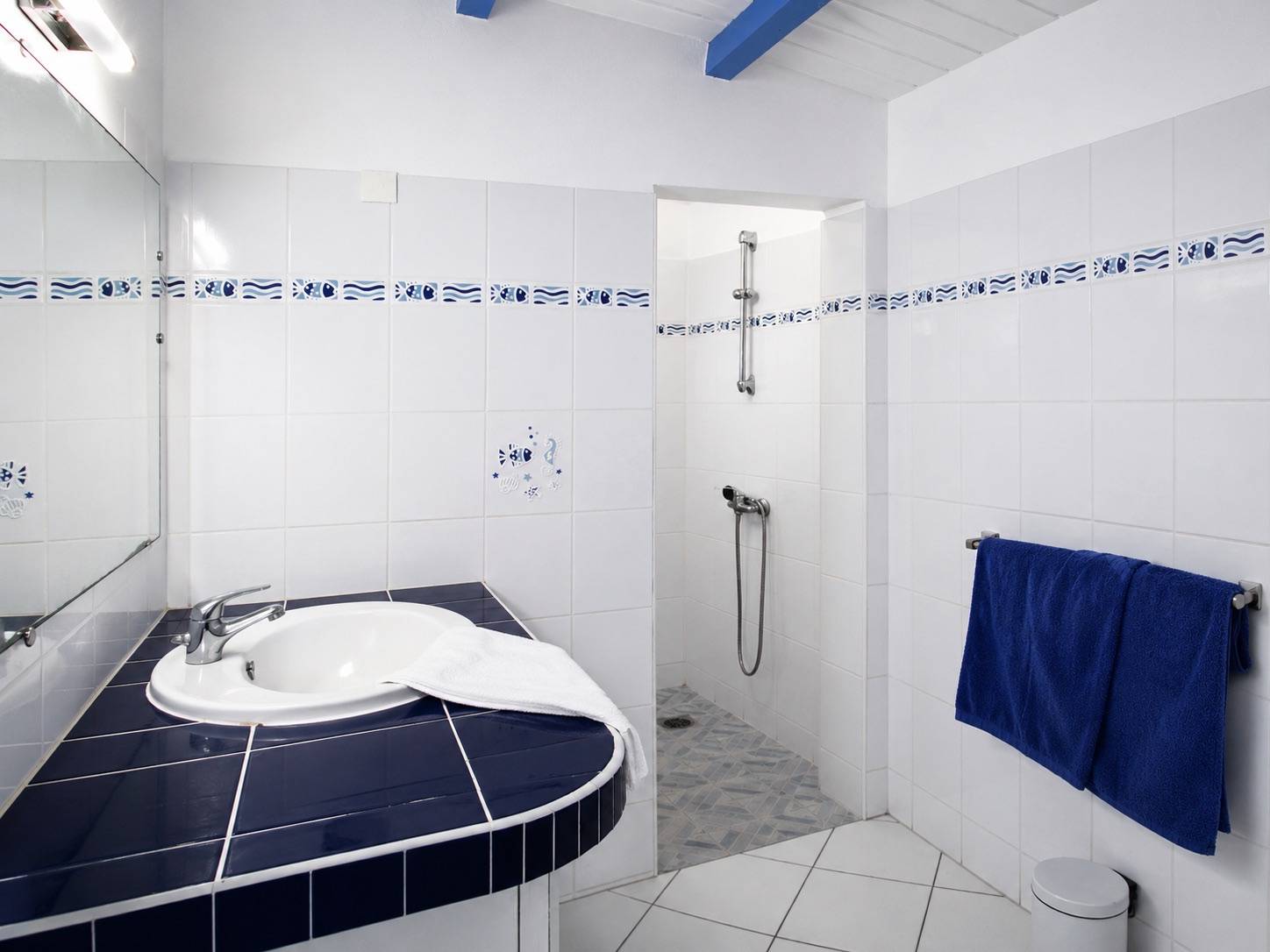 Salle de bain moderne avec douche à l'italienne dans un bungalow de vacances à Deshaies en Guadeloupe.