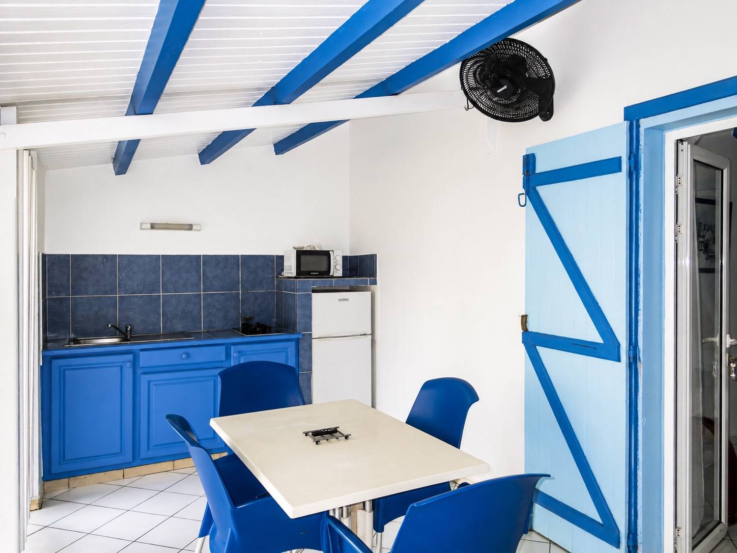Cuisine équipée avec coin repas dans un bungalow de location à Deshaies en Guadeloupe.