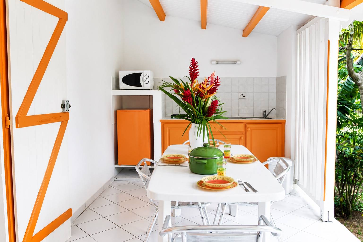 Cuisine extérieure avec terrasse et coin repas dans un bungalow de location à Deshaies en Guadeloupe.